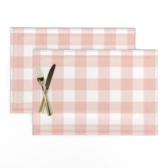 two placemats with gold forks and knife on them, one in pink checkered fabric