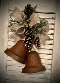 two bells with pine cones hanging from them