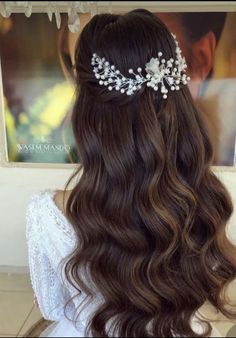 the back of a woman's head with long wavy hair and a tiara