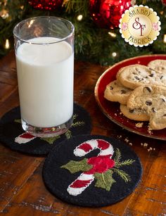 cookies and milk sitting on a table next to a christmas tree