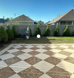 a backyard with a checkerboard pattern on the ground and a white frisbee flying through the air