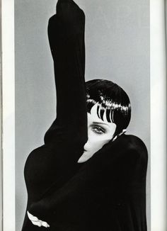 a black and white photo of a woman with her arms in the air