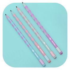 four pastel colored pencils lined up on a blue background