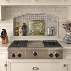 a white stove top oven sitting inside of a kitchen next to a counter with bottles on it