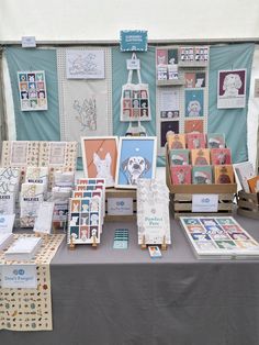 A photo of our stall at the Northeast Dog Festival 2023! We were able to hang behind us a large sheet in our branded Oldmangrey pale mint green tone, which then created a canvas for our two white peg boards to hang and our 2024 Calendar, dog tote bag, name sign, tea towel, A3 dog print and more! On the table at varying heights was our Xmas cards, dachshund wrapping paper, notebooks, colouring books, sale box, dog cards and more! Art Stall Display Ideas, Stall Display Ideas, Craft Stall Display Ideas, Market Stall Display Ideas, Dog Festival, Art Festival Booth, Craft Stall Display, Craft Show Table, Art Fair Display