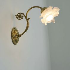 a wall light with a white flower on it