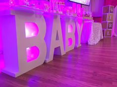 the bar is decorated with pink and white lights for a baby's first birthday