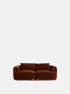 a brown couch sitting on top of a white wall