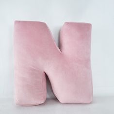 a pink pillow shaped like the letter n