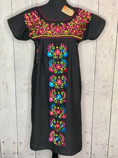 Black Floral Manta Mexican Dress. Beautiful embroidery can be dressed up or wear with sandals. Please feel free to contact us with any questions. Measurements upon request. Black Floral Embroidered Beach Dress, Black Floral Embroidered Dress For Beach, Beach Black Embroidered Dress With Floral Details, Black Beach Dress With Floral Embroidery, Black Embroidered Dress With Floral Details For Beach, Traditional Black Embroidered Beach Dress, Traditional Black Embroidered Dress For Fiesta, Traditional Black Embroidered Dress For Beach, Black Embroidered Dress For Fiesta With Floral Details