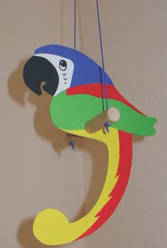 a colorful bird hanging from the side of a wall