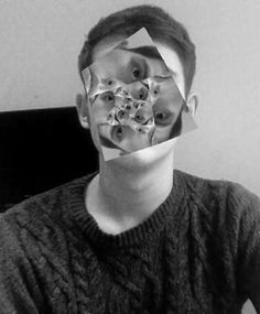 a man with paper covering his face in front of him is looking at the camera