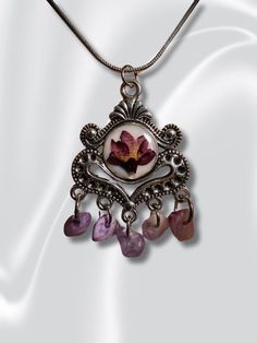 A silver-colored pendant in a mesmerizing design with Amethyst stones and a magical flower. The pendant brings with it a touch of charm and romance, and is decorated with delicate details. Comes with an elegant silver plated necklace. Straight from the world of fairy tales. About this item Each pendant is made with love, hand crafted and unique. ♥  Pendant size: 2.6 cm X 3.1 cm /  1.02"x1.22" approx. ♥ Care Instructions - Do not get wet or expose the product to fire. ♥ Delivery time - I ship by Fairy Core Jewelry, Necklace Fairy, Whimsical Gifts, Amethyst Stones, Fairy Core, Silver Plated Necklace, Delicate Details, Unique Pendant, Pressed Flower