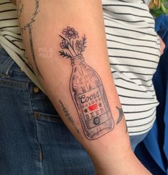 a woman's arm with a bottle tattoo on it