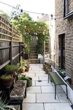 an alley way with potted plants and benches