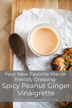 a bowl of sauce next to some food on top of a wooden cutting board with the words, your new favorite macro - friendly dressing - spicy peanut ginger vinaignette