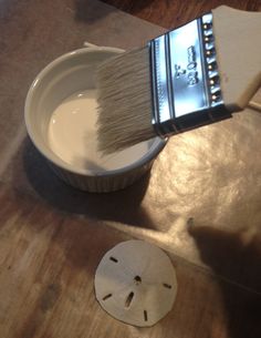 a brush is being used to paint a white bowl