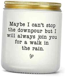 a white jar with a gold lid that says maybe i can't stop the downpour but i will always join you for a walk in the rain