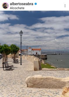 a bench sitting on top of a sidewalk next to the ocean