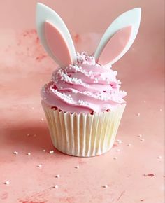 a cupcake with pink frosting and bunny ears