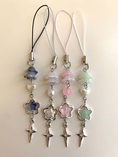 six different colored charms hanging on a white wall