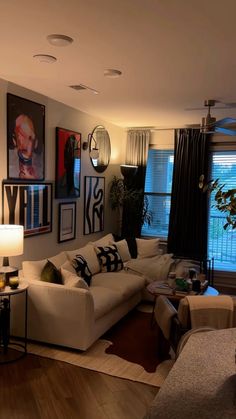 a living room filled with lots of furniture and pictures on the wall above it's windows