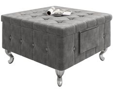 a grey ottoman sitting on top of a wooden table