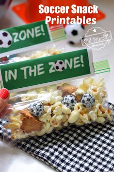 someone is holding up some snacks in the bag for soccer snack printables on their table