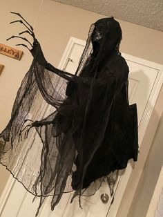 a person in a black costume is standing on the door way with their arms outstretched