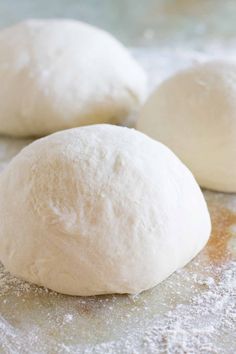 three uncooked doughnuts sitting on top of a table