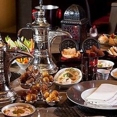 a table filled with lots of food and silver wares on top of each other