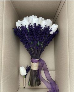 a bouquet of white and purple flowers in a box