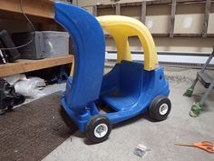 a blue and yellow toy car sitting in a garage