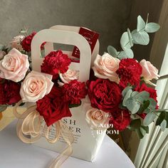 a bouquet of red and pink flowers sitting on top of a table