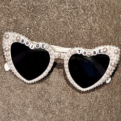 💖💖 Step into the enchanting world of our meticulously crafted heart-shaped sunglasses, where passion meets precision in every detail. Adorned with exquisite pearl embellishments, these sunglasses are a testament to artisanal artistry, perfect for your bridal ensemble. 💍💍 Elevate your bridal style effortlessly with these stunning sunglasses, designed to enhance your special moments. Whether it's your wedding day, honeymoon, bridal shower, or bachelorette party, let these shades add a touch of elegance to your bridal look. 📸📸 Planning an engagement photoshoot? Embrace the journey to "I do" with these sunglasses as the perfect accessory. Treat yourself or surprise a soon-to-be bride - these shades are guaranteed to sparkle and shine! 🎨🎨 Capture pure joy in every selfie with these pear White Heart-shaped Sunglasses With Gradient Lenses, White Sunglasses With Gradient Lenses As Gift, White Sunglasses With Gradient Lenses As A Gift, Heart-shaped Sunglasses For Summer Weddings, Heart-shaped Wedding Sunglasses For Summer, Groom Sunglasses, Sunglasses Bachelorette Party, Sunglasses Bride, Sunglasses Bachelorette