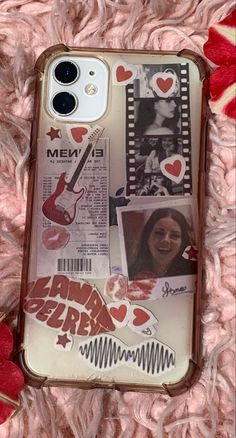 an iphone case with pictures and stickers on it sitting on a pink blanket next to hearts