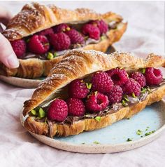 two croissants with raspberries on them