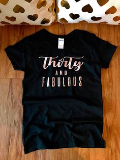 a t - shirt that says thirty and fabulous on the front, sitting on a wooden floor