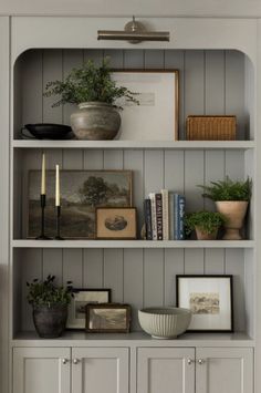 a book shelf filled with books and plants