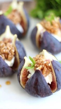 figs with nuts and cheese are on a white plate