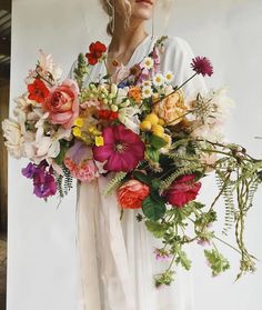 a woman holding a large bouquet of flowers