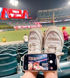 someone is taking a photo with their cell phone at a baseball game in the stadium