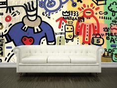 a white couch sitting in front of a colorful wall