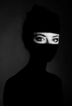 a woman's face is covered by a black mask