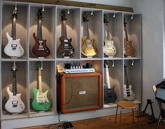 guitars are lined up on shelves in a room