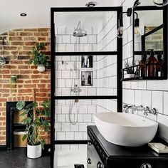 a black and white bathroom with brick walls