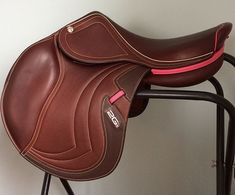 a brown saddle sitting on top of a black chair