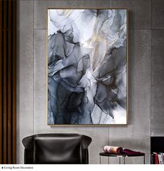 an abstract painting hangs on the wall above a chair and side table in a modern living room