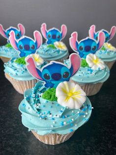 some cupcakes with blue frosting and decorations on them