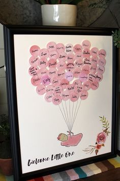 a pink balloon with lots of writing on it is in front of a potted plant